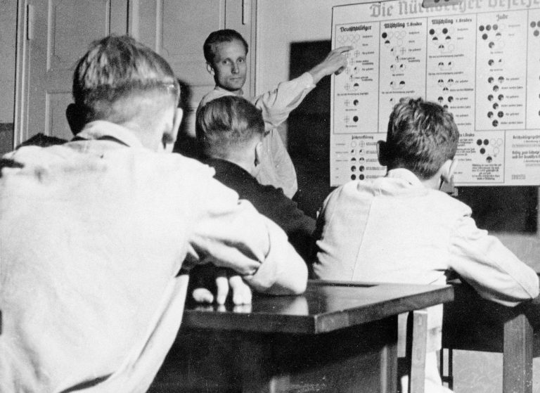 The “Nuremberg Laws” are explained during an “ideological training” program in the Hitler Youth camp at Hohenelse in Brandenburg, 1937  According to the “Reich Citizens Act,” announced at the NSDAP party conference in Nuremberg in 1935, one’s Jewishness is determined by the religious affiliation of one’s grandparents. The act declares Jews to be second-class citizens. The “Blood Protection Act” makes sexual relations between “Jews” and “gentiles” a crime; special courts convict numerous Jewish men. SZ Photo, München